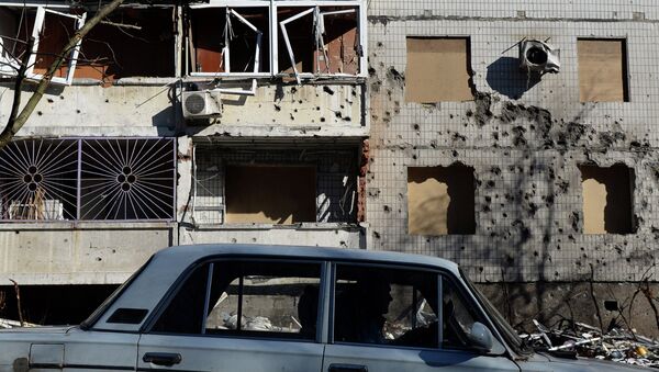 Машина перед поврежденным зданием в Донецке. Архивное фото