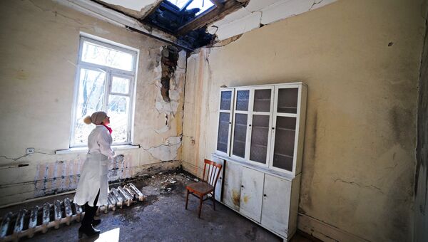 Сотрудница осматривает повреждения после обстрела в городской больнице № 20 в Донецке