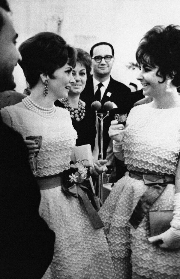 Джина Лоллобриджида и Элизабет Тейлор в платьях Диор беседуют в Кремле во время Московского международного кинофестиваля. 1961