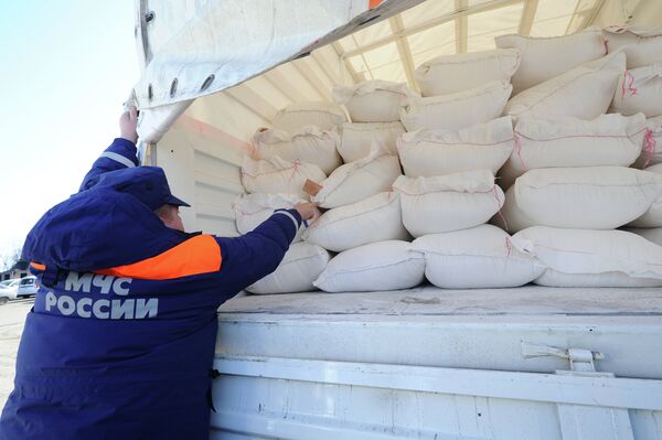 Сотрудник МЧС России демонстрирует содержимое груза с гуманитарной помощью