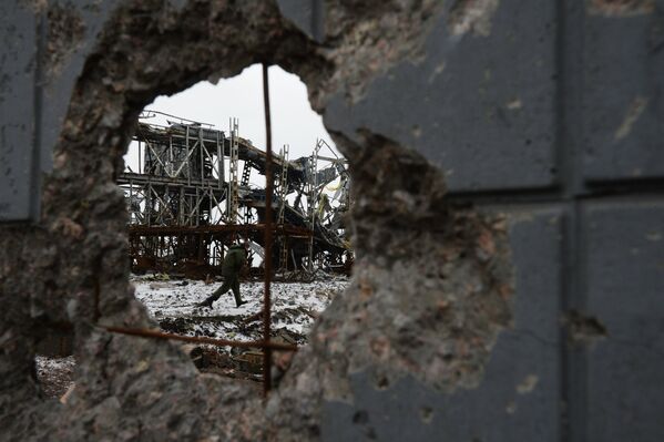 Ополченец Донецкой народной республики (ДНР) у разрушенного в результате обстрела здания в аэропорту города Донецка