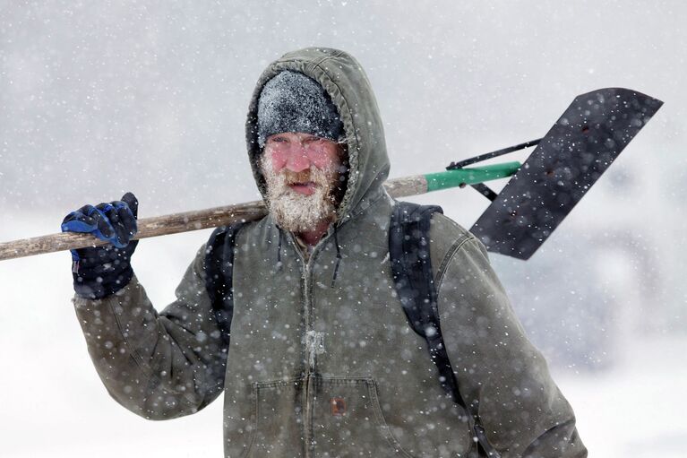 Мужчина с лопатой во время снегопада в Лексингтоне