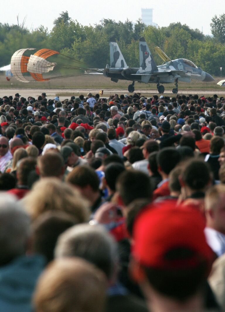 Посетители Международного авиационно-космического салона МАКС-2009 наблюдают за посадкой истребителя Су-30 МКИ на аэродроме в Жуковско