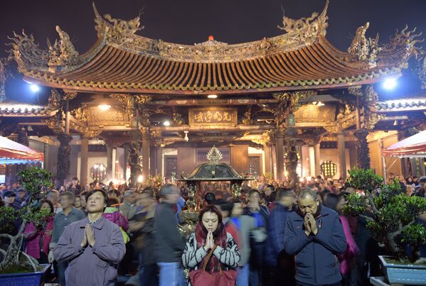 Местные жители молятся о счастье во время церемонии в одном из храмов Тайбэя