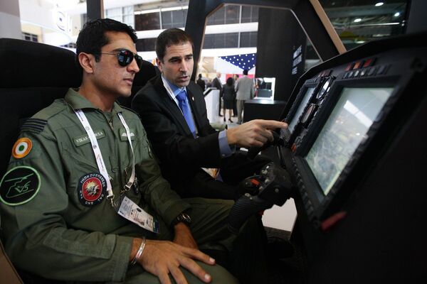 Участник авиасалона Aero India-2015 из Израиля показывает индийскому пилоту систему управления вооружением