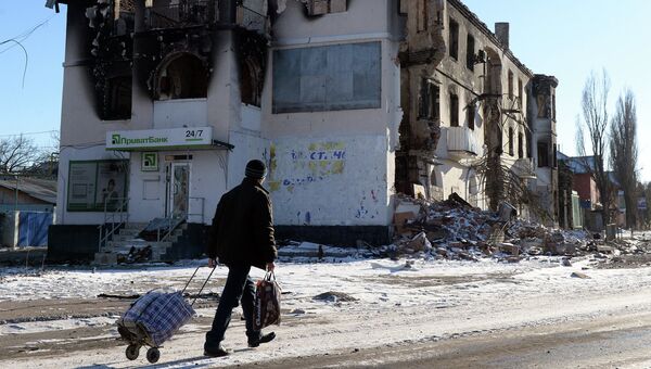 Мужчина проходит мимо дома, разрушенного в результате обстрела. Углегорск, Украина. 18 февраля 2015