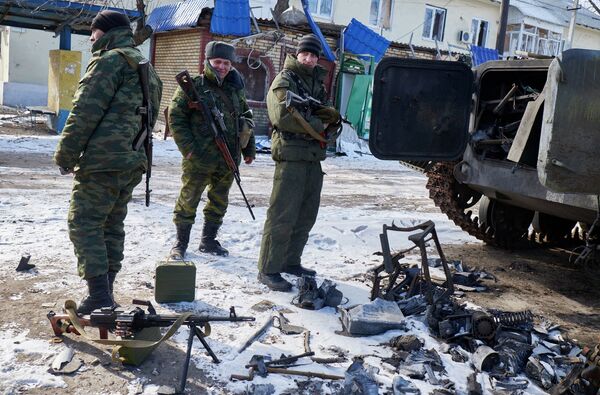 Ополченцы возле сгоревшей БМП ВСУ около мобильного пункта помощи населению, организованного МЧС ДНР