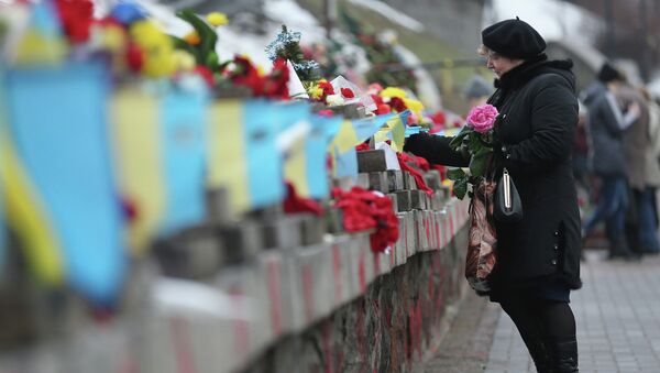 Женщина возлагает цветы в память о погибших во время прошлогодних событий на площади Независимости в Киеве. Архивное фото