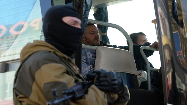Ополченец охраняет автобус с украинскими силовиками во время обмена пленными. Архивное фото