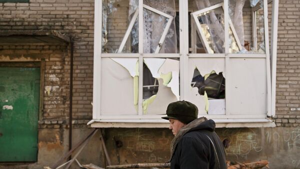 Женщина идет возле поврежденного дома в Дебальцево. Архивное фото