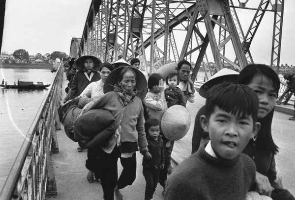 Группа вьетнамских беженцев пересекают мост через реку Хыонг. 19 февраля 1968