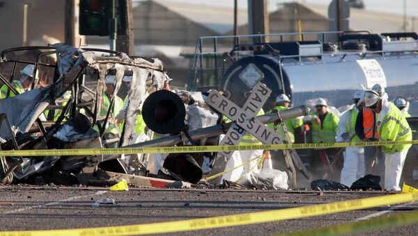 Рабочие расчищают дорогу на месте столкновения поезда и грузовика в Калифорнии, США