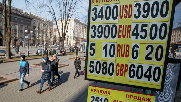 Люди проходят мимо табло с курсом валют в центре Киева 25 февраля 2015
