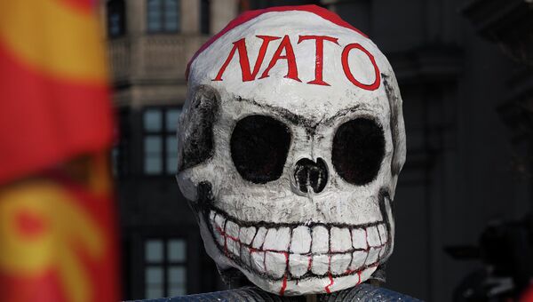 Маска на демонстрации против политики НАТО на площади у городской ратуши в Мюнхене