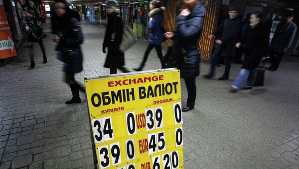 Люди проходят мимо табло с курсом валют в центре Киева 25 февраля 2015