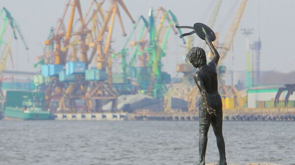 Памятник мальчику с бескозыркой и собакой, который провожает корабли в морском грузовом порту Клайпеды