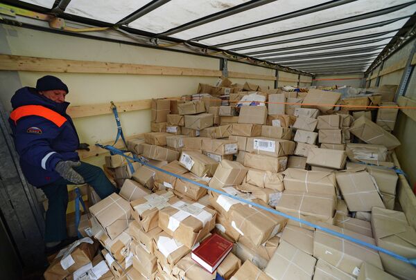 Сотрудник МЧС России демонстрирует книги - гуманитарный груз одного из грузовых автомобилей шестнадцатого российского гуманитарного конвоя