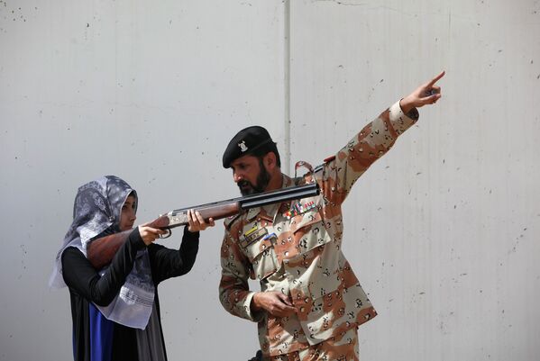 Военный дает инструкции студентке во время антитеррористических учений в Пакистане
