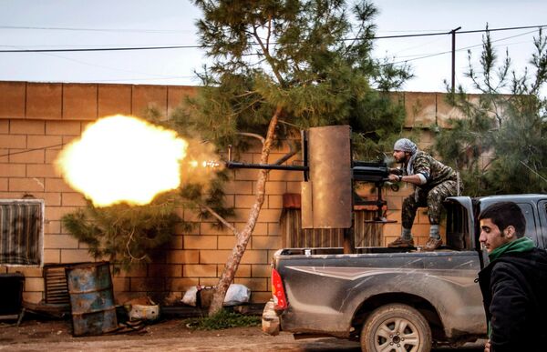 Курдский боец стреляет из зенитной установки по позициям боевиков ИГИЛ в районе Тель-Тамр