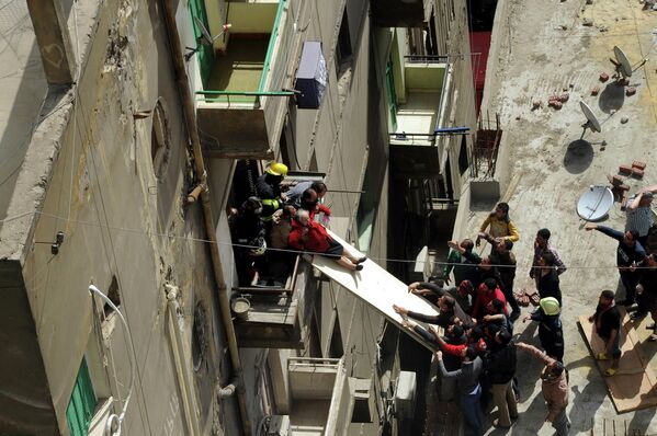 Спасатели эвакуируют пожилую женщину из ее квартиры в центре Каира