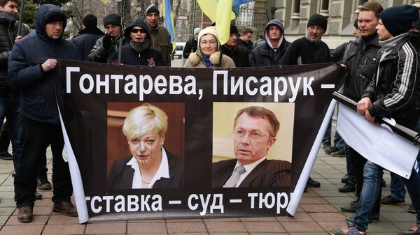 Участники акции протеста у Нацбанка Украины в Киеве, на плакате справа бывший первый замглавы Национального банка Александр Писарук