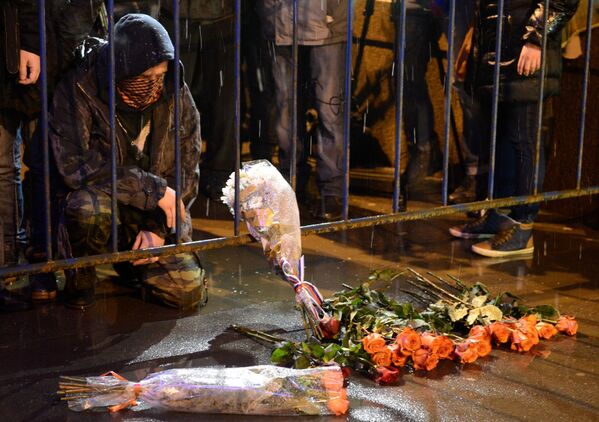 Люди несут цветы к месту убийства политика Бориса Немцова