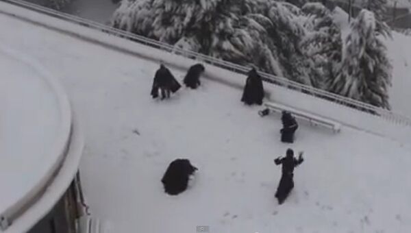 Монахи играют в снежки. Кадр из видео.