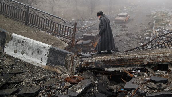 Пожилая женщина идет по разрушенному мосту возле аэропорта Донецка, Украина. Архивное фото