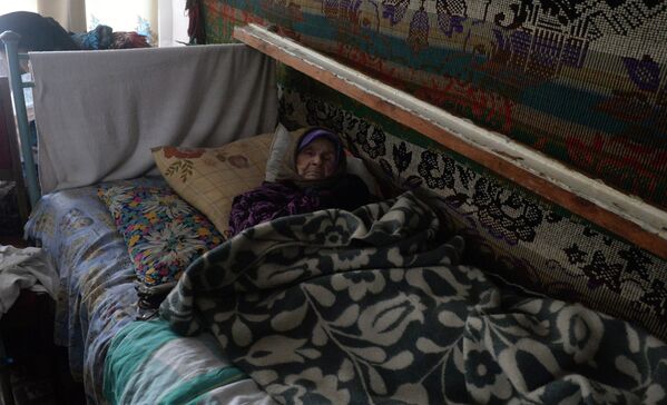 Девяностолетняя жительница города Дебальцево в своей квартире в жилом доме, где нет ни отопления, ни электричества
