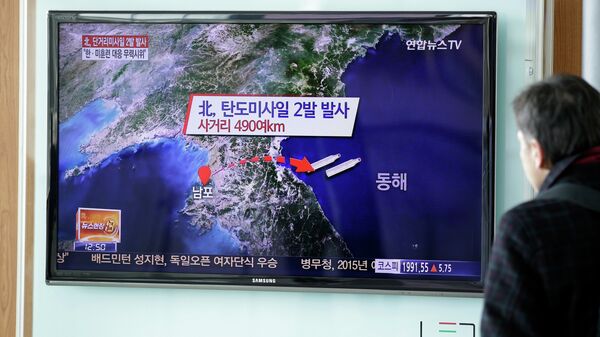 Житель Сеула смотрит по телевизору выпуск новостей о запуске двух баллистических ракет с территории КНДР