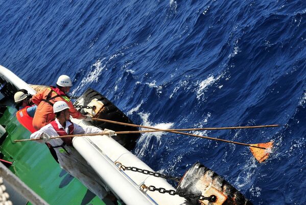 Китайские спасатели вылавливают из воды предметы на месте возможного крушения рейса MH370 авиакомпании Malaysia Airlines