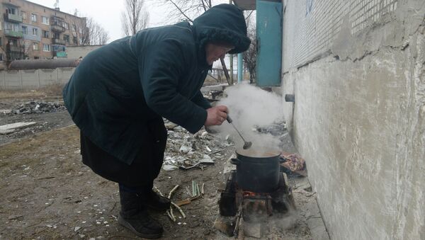 Жители города Дебальцево готовят еду на костре у подъезда пострадавшего в результате боевых действий жилого многоквартирного дома