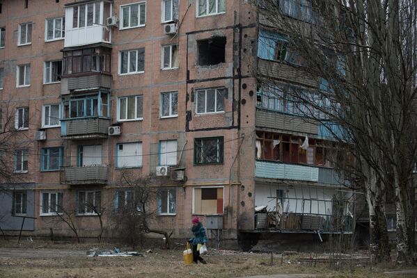 Женщина проходит мимо разрушенного жилого дома в Авдеевке, Украина