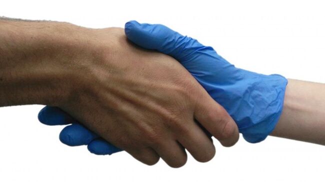 Ученый пожимает руку добровольцу в стерильной перчатке во время эксперимента