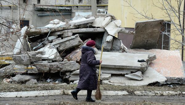 Женщина идет мимо разрушенного дома в Первомайске, Украина. Архивное фото