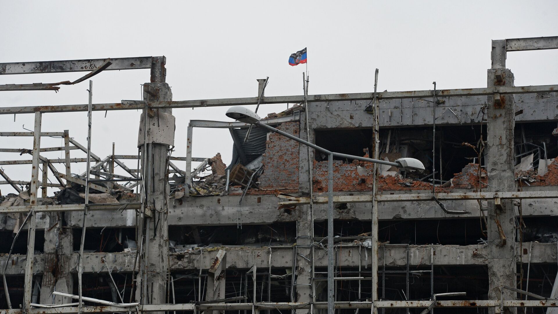 Флаг Донецкой народной республики над разрушенным зданием аэропорта города Донецка - РИА Новости, 1920, 21.02.2022