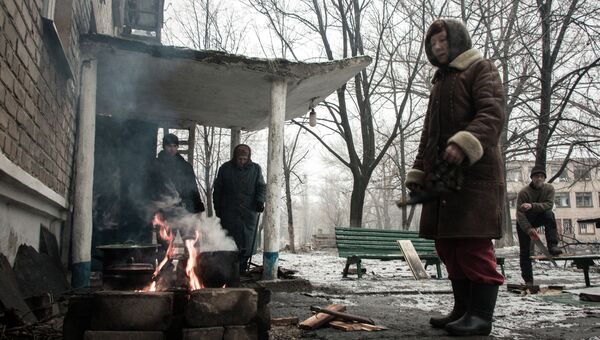 Жители города Дебальцево готовят еду на костре у подъезда многоквартирного жилого дома. Архивное фото