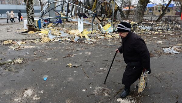 Пожилая женщина идет к автобусной остановке в Киевском районе Донецка