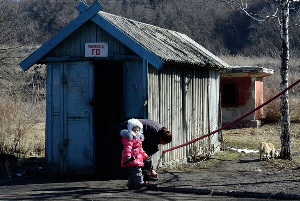 Женщина и девочка перед входом в бомбоубежище в районе аэропорта Донецка, Украина