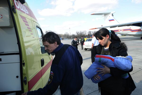 Женщина с ребенком, прошедшим лечение в специализированном медицинском учреждении Санкт-Петербурга, у машины скорой помощи в аэропорту Ростова-на-Дону