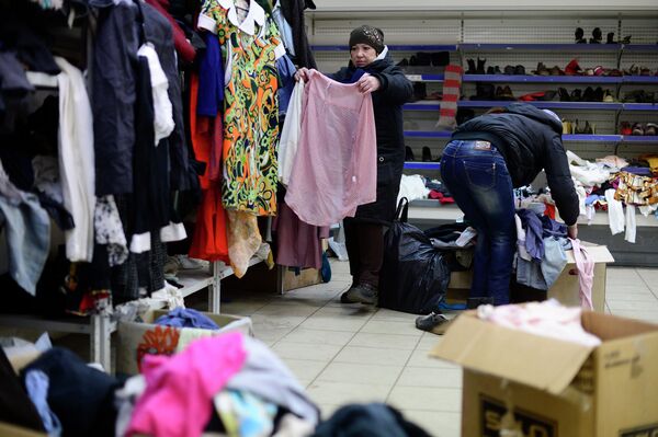 Женщина сортирует одежду в распределительном центре в Дебальцево, Украина