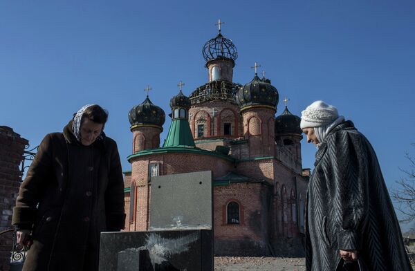 Женщины у поврежденной церкви Октябрьского района Донецка. Украина