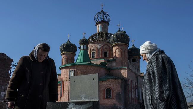 Женщины у поврежденной церкви Октябрьского района Донецка. Украина. Архивное фото