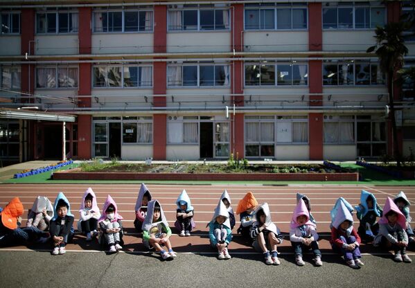 Школьники во время учений на случай землетрясения в Токио. 11 марта 2015