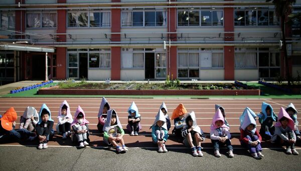 Школьники во время учений на случай землетрясения в Токио. 11 марта 2015