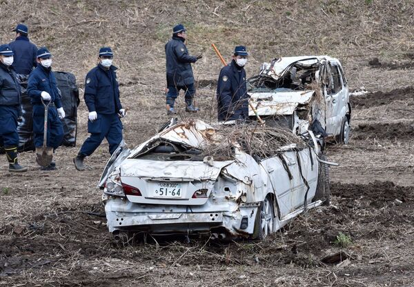 Полицейские во время поисков останков пропавших без вести в районе АЭС Фукусима, Япония. 11 марта 2014