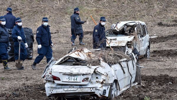 Полицейские во время поисков останков пропавших без вести в районе АЭС Фукусима, Япония. 11 марта 2014. Архивное фото