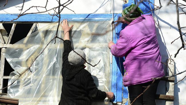 Жители села заклеивают разбитое окно. Архивное фото