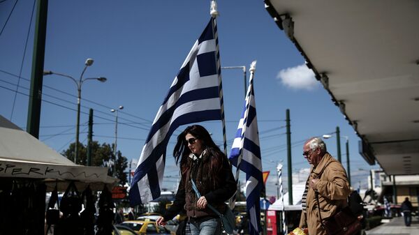 Люди на одной из улиц города Афины в районе Пирея. Март 2015