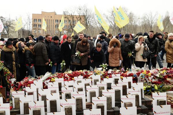 Участники Марша белых платков возлагают цветы к мемориалу Небесной сотни в центре Киева